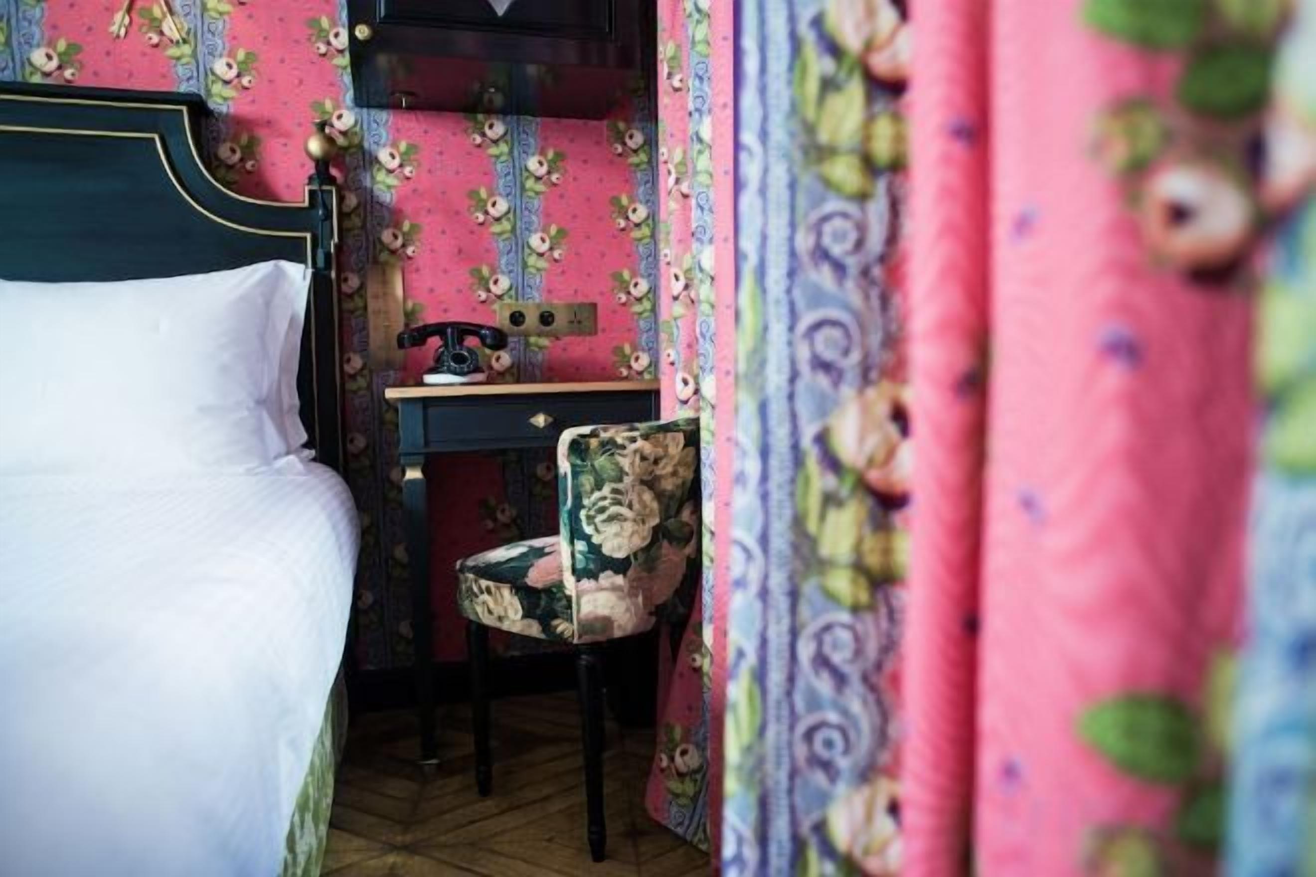 A bedroom with a bed, a desk, and a chair.