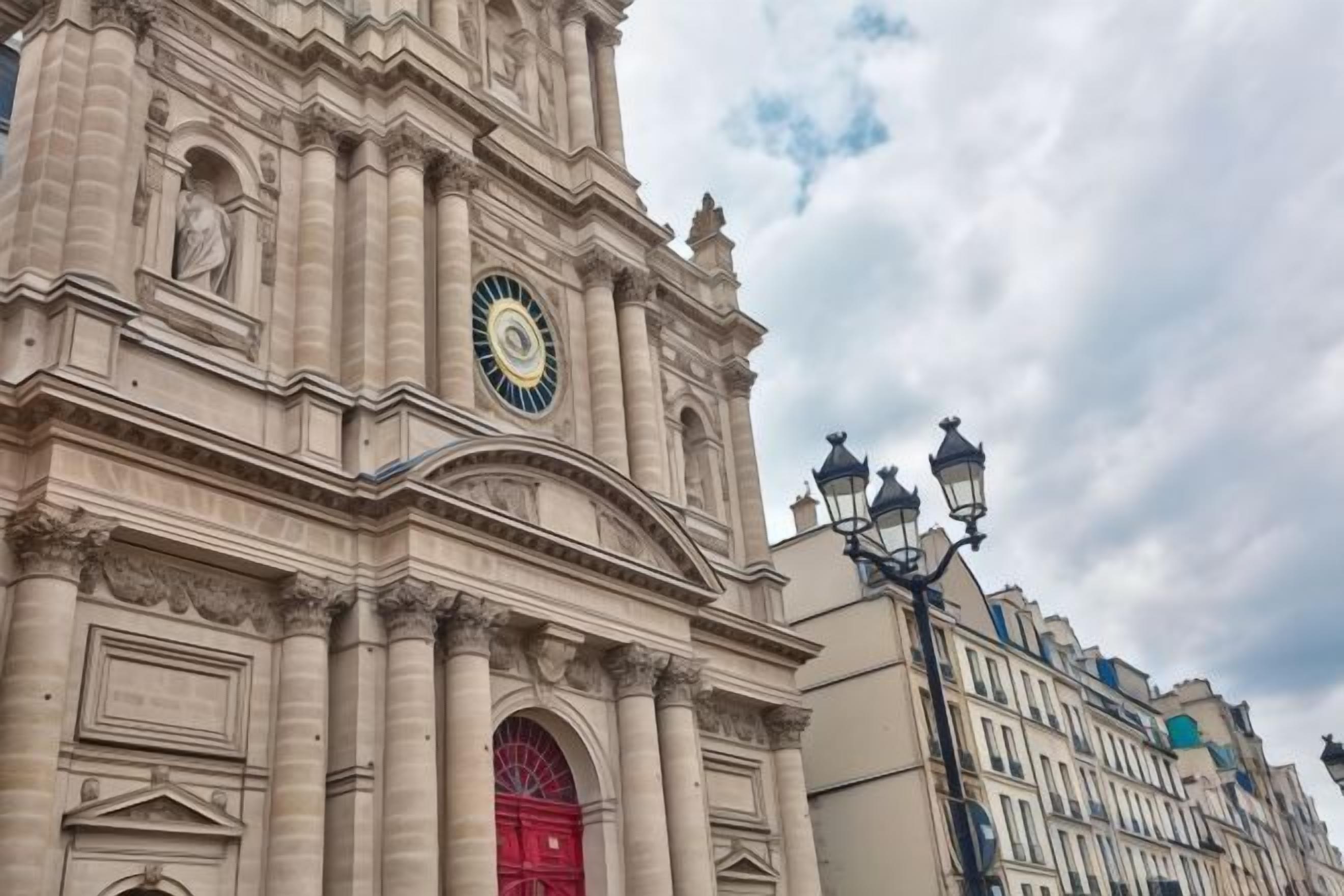 A historic building with a prominent clock tower, a red entrance, and classical architectural details.