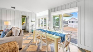 Amplia sala de estar con comedor, ventanas grandes y vistas al exterior.