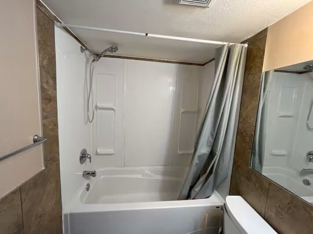 A bathroom with a bathtub, a shower, and a toilet.