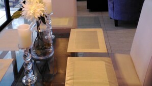 Un salon moderne comprenant un ensemble de canapés, une table basse et des vases décoratifs ornés de fleurs.