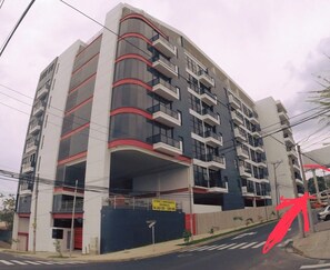 A multi-story building with balconies, a sign indicating availability of apartments, and a street view. - Best Location San Salvador, Escalón, Torre 91. N6 (San Salvador)
