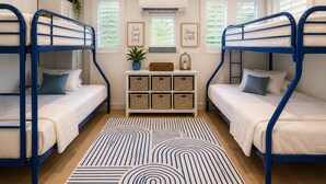 A room with bunk beds, a white cabinet with baskets, a potted plant, and two framed signs. - The Blue Coconut • Pool • Pergola • Steps from Boqueron Beach (Boquerón)
