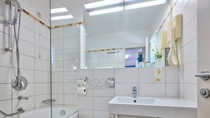 Ein modernes Badezimmer mit Badewanne, Toilette und Waschbecken.