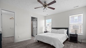 A bedroom with a bed, a nightstand, a ceiling fan, and a window with blinds. - Quaint Cottage-3BR/2B House with Arcade and Fire Pit in Quiet Part of Hope Mills (Hope Mills)