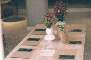 A table set with vases of flowers and a menu. - Mona Athens (Athens)