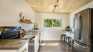 Una cocina moderna con una isla central, electrodomésticos de acero inoxidable y un ventanal que proporciona luz natural.