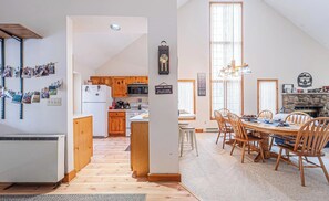 Una cocina amplia con armarios de madera, una isla central y un comedor con una mesa grande y sillas.