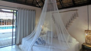 A bedroom with a bed under a canopy, a ceiling fan, and a view of a pool through large windows. - Magic Xcacel Tulum (Tulum)