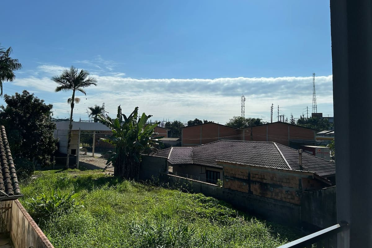 A residential area with houses, a palm tree, and a clear sky.