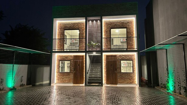 A modern building with a brick facade, multiple balconies, and a central staircase. - Apartamentos Bora Bora Hospedagens (Joinville)