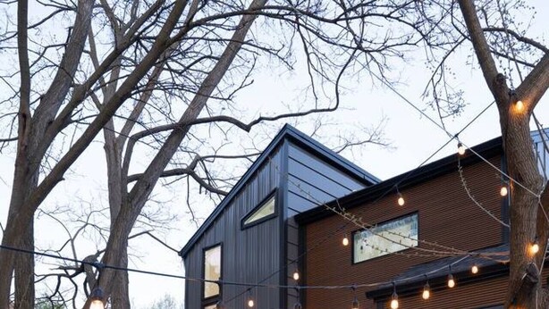 Ein modernes Haus mit Glasbalkon, Whirlpool und Lichterkette.