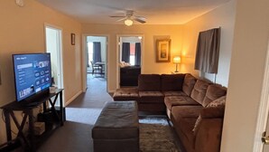 A living room with a sectional sofa, a television on a stand, and a ceiling fan. - 3-bedroom apartment in beautiful Mexico with WiFi, AC. Start your vacation now (Mexico)