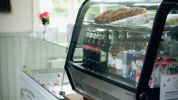 Vitrina de forn amb pastissos i ampolles de refrescos.