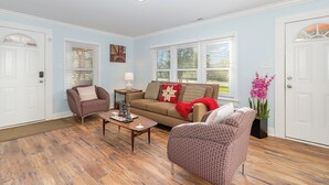 A living room with a brown sofa, patterned armchairs, a wooden coffee table, and a potted plant. - Modern And Cozy House In The Heart Of Hillsborough (Hillsborough)