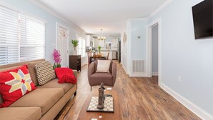 A living room with a sofa, a coffee table with a chess set, and a chair. - Modern And Cozy House In The Heart Of Hillsborough (Hillsborough)