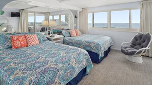 A hotel room with two beds, a chair, a desk, and a view of the sea. - 2BR Atlantis, Family Friendly, 16th fl Oceanfront Views, Outdoor Oceanfront Pool (Ocean City)
