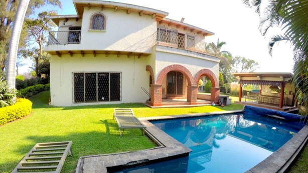 A two-story house with a swimming pool, a covered patio, and a well-maintained lawn. - Casa Grande Lomas de Cocoyoc (Fraccionamiento Lomas de Cocoyoc)
