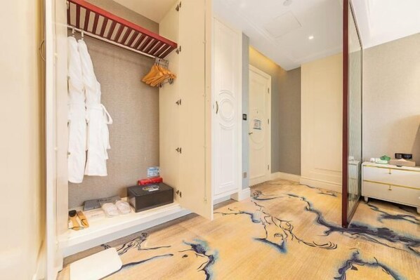 Une chambre d’hôtel dotée d’un dressing, d’un miroir et d’une moquette à motifs.