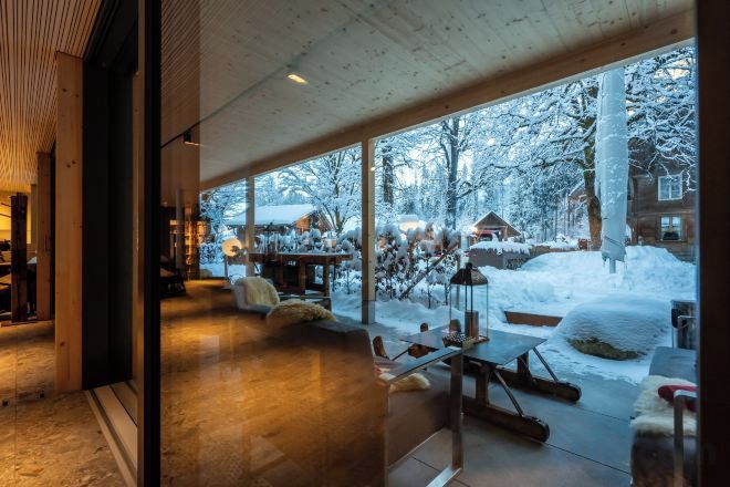 A modern interior with large windows overlooking a snowy outdoor area.
