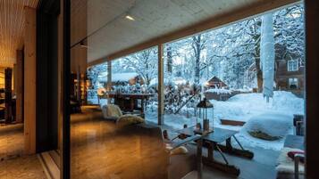 A modern interior with large windows overlooking a snowy outdoor area.
