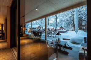 Un interior moderno con ventanas amplias que dan a un paisaje nevado.
