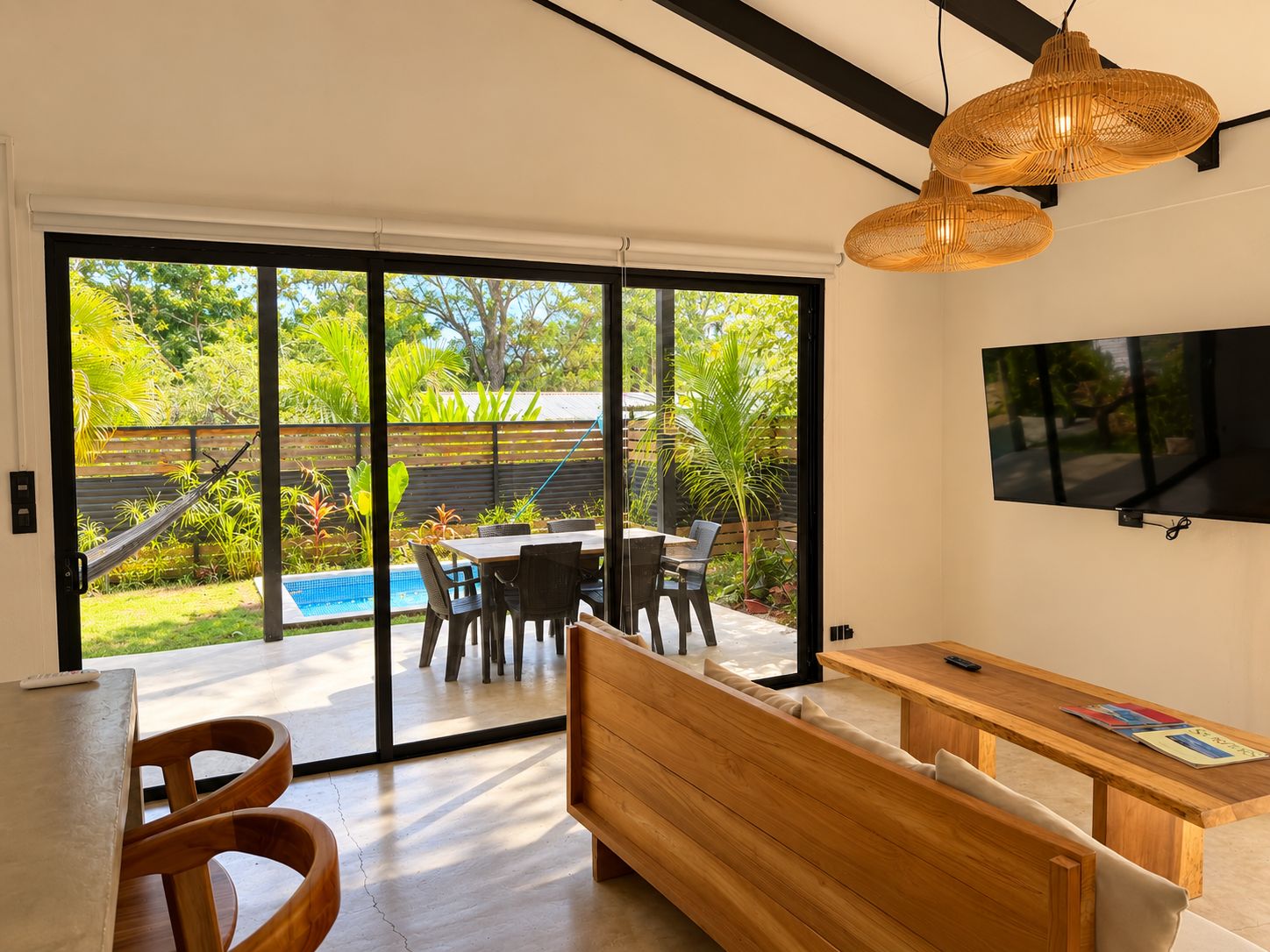 Un intérieur moderne comprenant un coin repas, un banc et un téléviseur fixé au mur.