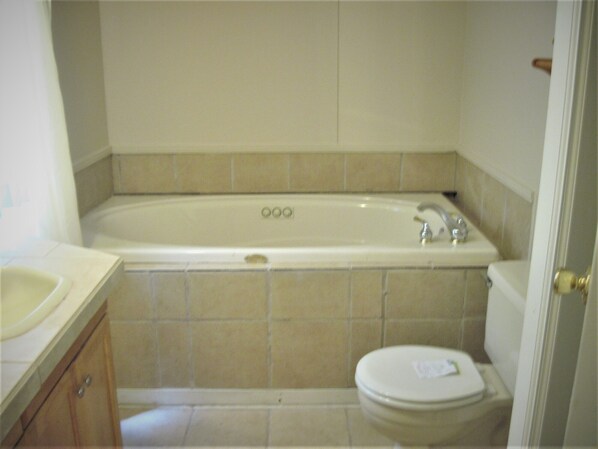 Un baño con bañera, inodoro y lavamanos.