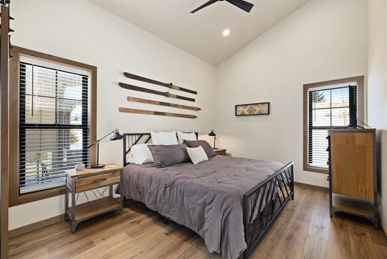 A bedroom with a bed, bedside tables, a desk, and a wardrobe.