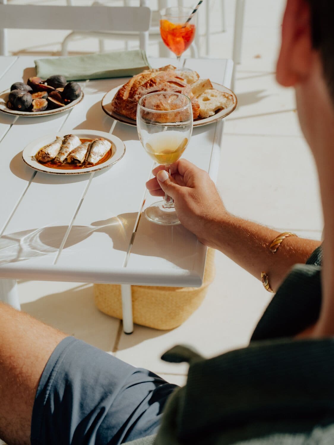 A dining table with plates of food and a glass of wine.