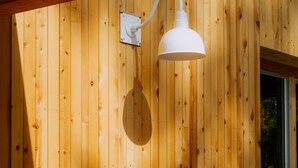 Pared de madera con una lámpara colgante blanca.