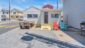 A small, single-story house with a front porch, a mailbox, and a door with a doormat.