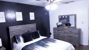 A bedroom with a bed, a ceiling fan, a dresser, and a mirror. - Cozy 2-bedroom condo with WiFi, AC in quiet NW Gainesville, FL (Gainesville)