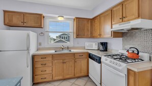 A kitchen with wooden cabinets, a white refrigerator, a stove, and a microwave. - Lavallette Heart of Town 2 Family Beach Block 2 Bedroom Available! (Lavallette)