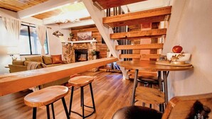 A cozy living area with a wooden bench, a fireplace, and a staircase.