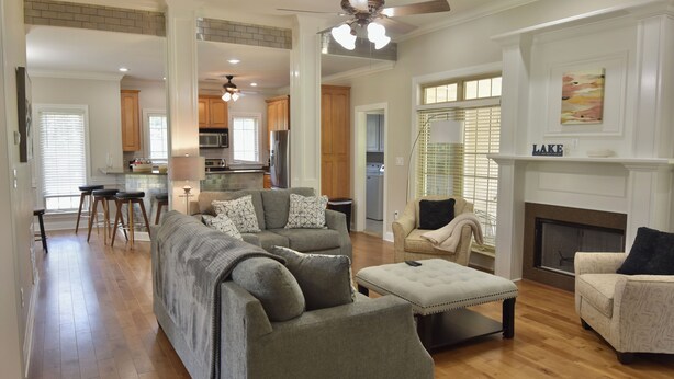 A spacious living room with a large gray sectional sofa, a beige armchair, and a fireplace. - Spacious 4 Bed Island House on Lake Hamilton with Boat Slip (Hot Springs)