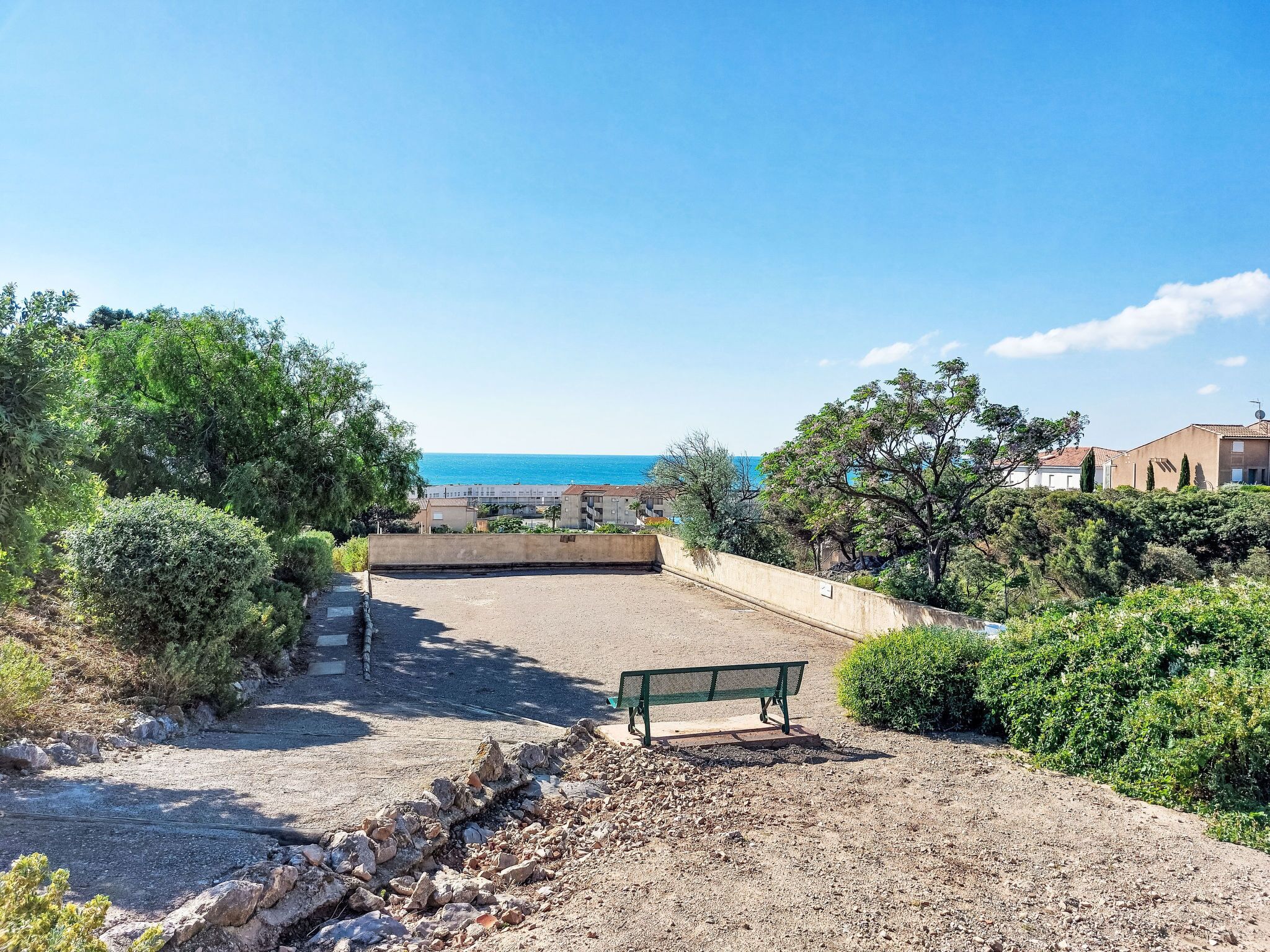 A coastal view with a bench and rocky terrain.