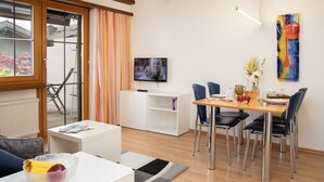 Un salon moderne comprenant un coin repas, un téléviseur et un tableau accroché au mur.