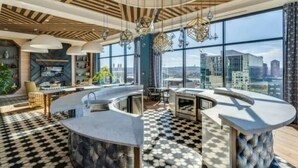 A modern kitchen with a curved island, large windows, and a checkered floor. - City Club - Unit 429 (Cincinnati)