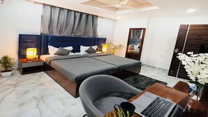 A modern bedroom with a large bed, bedside tables with lamps, a desk with a laptop, and a mirror. - Housr Rushikonda Visakhapatnam (Visakhapatnam)