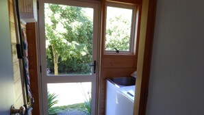 A compact kitchen with a sink, a window, and a door leading to an outdoor area. - Family Cottage on Established Rural Farm. Relaxing, Secluded, has Beautiful View (Broomfield)