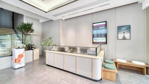A modern reception area with a glass counter, wooden benches, and a staircase. - gangduhotel (Shaoxing)
