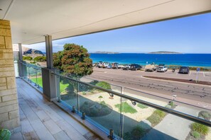Ein Balkon mit Blick auf einen Parkplatz und das Meer.