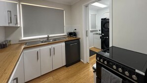 Una cocina moderna con armarios blancos, una estufa negra y un lavavajillas.