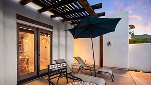A patio with a covered seating area, a pool, and a door leading to an interior space. - Private Pool Home with Patio | La Quinta Cove (La Quinta)