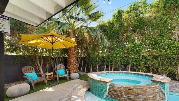 A backyard with a swimming pool, outdoor chairs, and a yellow umbrella. - Palm Springs Mid-Century | Mtn Views, Pool & Spa (Palm Springs)