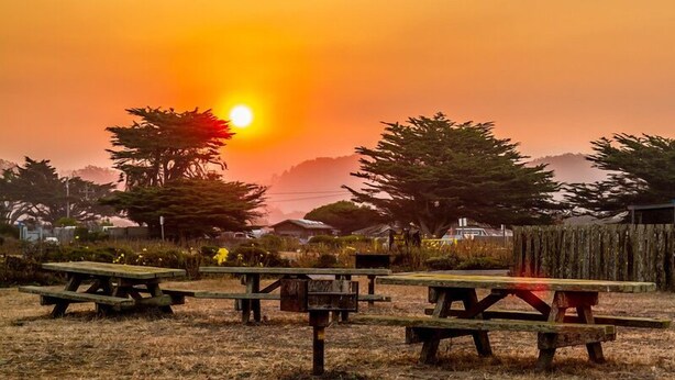 A sunset over a park with picnic tables and trees. - Fantastic 3 bedroom, 3 bath Coastal Home Close to the Beach and Restaurants (Moss Beach)