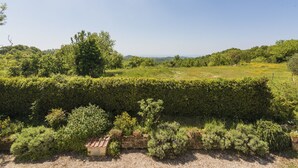 A landscaped garden with a variety of shrubs and a small brick structure. - Allumiere by Interhome (Manziana/Canale Monterano)