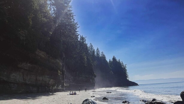 Una playa con un acantilado rocoso y vistas al océano.