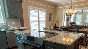 A modern kitchen with a central island, built-in oven, and granite countertop. - Historic 1905 Victorian Home Near the  Rainbow River  & World Equestrian center (Dunnellon)